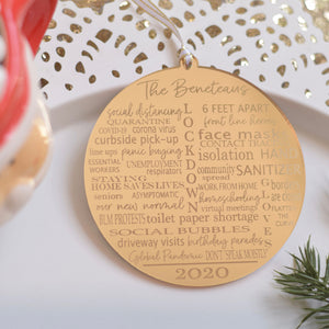 Gold 2020 pandemic ornament on a white plate with greenery
