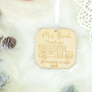 Mrs Birch Thank you for keeping us safe Christmas ornament with a bus. Lying on a piece of white fur with decorations around it