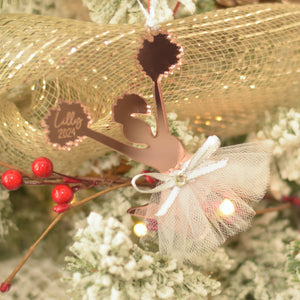 Rose Gold Cheerleader Christmas tree ornament on a white flocked tree