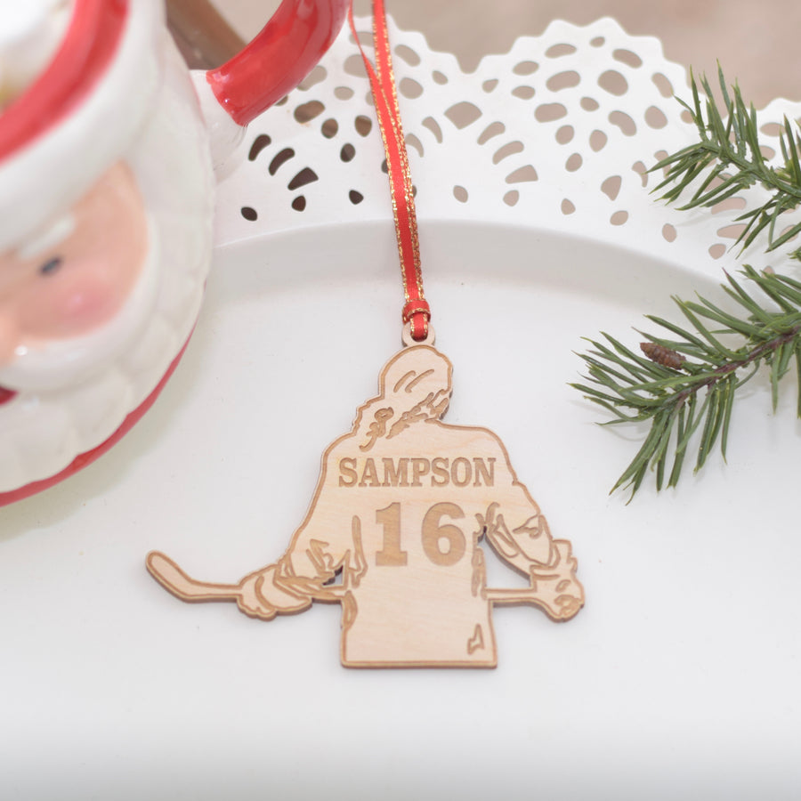 Girl hockey player ornament with Christmas greenery and a mug