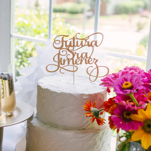 Gold Futura Señora Cake Topper on cake with champagne and flowers