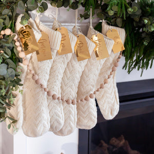 Stockings on a mantle with customized engraved stocking name tags.