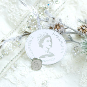 Silver Queen Elizabeth Christmas tree ornament next to a nickel to show for size as well as to show that it is a replica of the back of a Canadian coin.