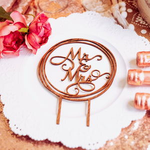 Wooden Mr and Mrs Cake topper on a plate with roses and champagne