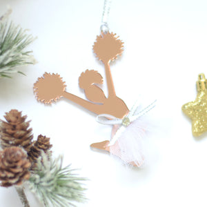 Cheerleading gifts on a white surface with Christmas greenery