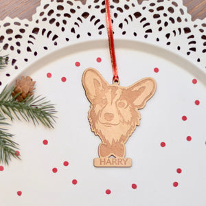 Corgi wooden ornament with a bowtie placed on a white cake plate with red confetti