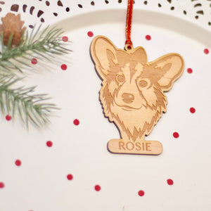 corgi dog ornament laser cut out of wood with christmas greenery and red confetti around it