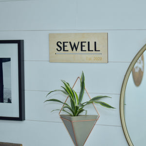 Name and established year sign hanging on a shiplap wall