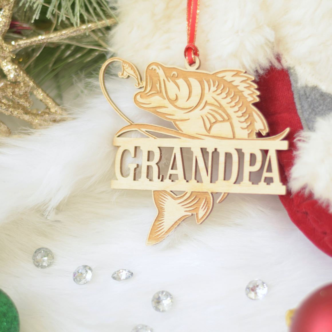 Grandpa fishing ornament on a stocking with Christmas greenery
