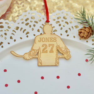 hockey jersey ornament with name and number on a white cake plate with red confetti