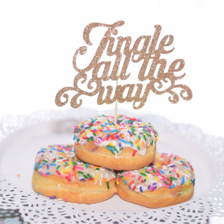 Jingle all the way pink sparkle cake topper placed in three sprinkle donuts