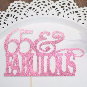 65 & fabulous pink sparkle glitter cake topper on white plate background
