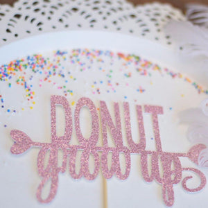 donut grow up pink sparkle glitter cake topper on white plate with sprinkles