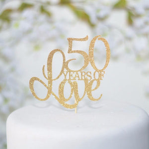 50 years of love gold glitter cake topper on white cake
