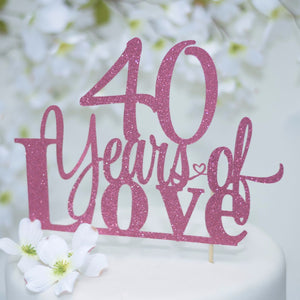 40 years of love pink glittery sparkle cake topper on white cake