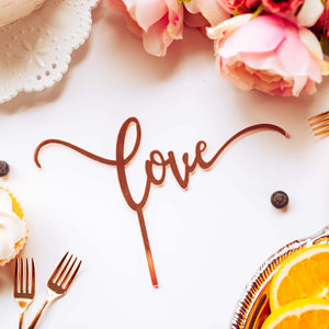 love script cake topper in rose gold at a party
