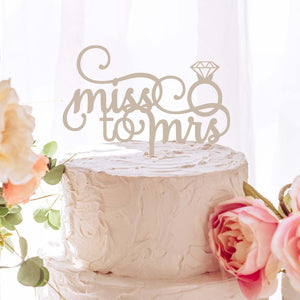 Miss to Mrs silver acrylic cake topper on a white cake with flowers