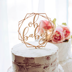 oh baby geometric cake topper on a naked cake for a baby shower