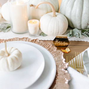 White pumpkins and gold place cards on a Thanksgiving table