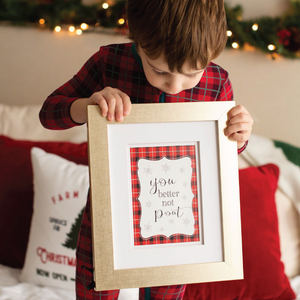 Boy in Christmas PJs holding a sign You better not pout Christmas photography